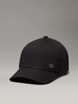 Gorra negra de algodón orgánico con logo CK metálico en el frente.