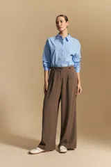 Pantalón ancho color marrón, de silueta moderna y calce cómodo, con diseño limpio y fluido. Presenta cierre frontal con botón y cordones ajustables en la cintura.