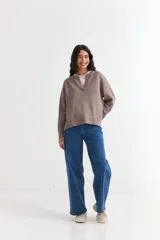 Sweater de tejido de punto color azul marino, con cuello abierto tipo polo y tajos laterales en el ruedo. Presenta mangas largas con puños acanalados y un corte holgado.