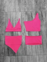 Conjunto de bikini fucsia neón, compuesto por un corpiño triangular y una bombacha cavada. También incluye un top de un hombro y una falda tubo.