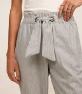 Pantalón baggy de sarga rayada, tiro alto, con lazo en la cintura y bolsillos laterales.