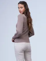 Buzo tejido Philosophy color beige, con cuello redondo y mangas largas abullonadas. Presenta detalles pointelle en la parte delantera y en las mangas.