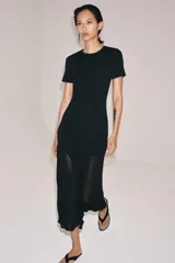 Vestido largo negro de punto con cuello redondo, manga corta y bajo con tejido combinado semitransparente.