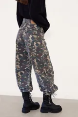 Borcego de caña corta confeccionado en cuero negro, con diseño de cordones y ganchos metálicos, cierre lateral y suela de plataforma dentada.