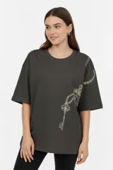 Remera oversize de algodón color gris oscuro, con cuello redondo, mangas cortas y estampado lateral en tonos claros de cadenas y una llave.