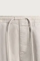 Bermuda cargo color negro de corte relaxed fit, confeccionada en tejido de algodón con elasticidad y efecto lavado. Cuenta con cintura elástica ajustable con cordón, bolsillos frontales y bolsillos laterales tipo cargo con solapa en las perneras.