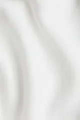 Buzo de punto fino color blanco, con escote amplio tipo barco que deja los hombros descubiertos y remates acanalados en puños y bajo.