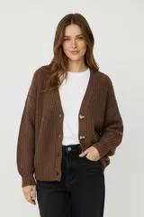 Cardigan de punto acrílico color marrón, con cuello en V, botones frontales y corte holgado.
