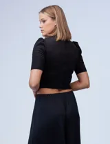 Top negro de símil gamuza, marca Tahari, con espalda con abertura central y cierre invisible.