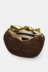 Mini bolso marrón trenzado con asa de mano dorada metálica y doble asa bandolera ajustable y extraíble. Incluye forro, bolsillo interior y cierre mediante cremallera.