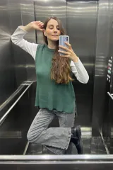 Chaleco tejido verde con tajos laterales.