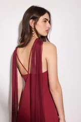 Vestido bordó con base de crepé asimétrico y capa de gasa. Incluye capa removible que puede usarse como chal o corbatín.