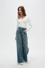 Pantalon de jean estilo wide leg con tiro medio, bolsillos laterales y traseros, y ruedo desflecado.