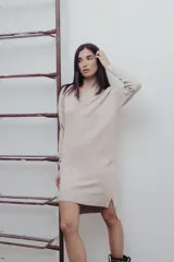 Vestido de punto color marrón, con escote en V, mangas largas y silueta recta con tajos laterales.