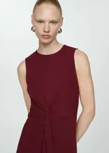 Vestido midi de algodón, sin mangas y con cuello redondo. Presenta un diseño recto con un detalle drapeado frontal tipo nudo en la cintura.