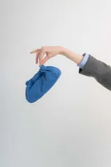 Cartera tipo sobre de cuero verde, con diseño fruncido y correa ajustable.
