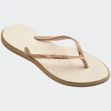 Ojotas Havaianas modelo Slim Point, con suela y tiras más finas, punta ligeramente puntiaguda y borde contrastante. Las tiras son de color lila claro con el logotipo de Havaianas en metalizado. La suela es lila claro con borde exterior en color terracota/rosado oscuro.