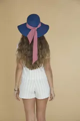 Sombrero de ala ancha color azul con cinta rosa.