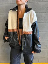 Campera negra con paneles de cuero sintético con textura de cocodrilo, corderito color crema en la parte superior y detalles en cuero marrón.