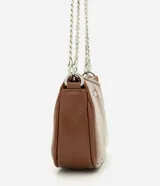 Cartera tipo baguette pequeña Satinato, confeccionada en PU color marfil, de formato alargado y estructura maleable. Cuenta con cierre superior de cremallera, placa frontal aplicada con el logo de la marca y asa de cadena doble metálica en tono plateado que permite llevarla al hombro o cruzada.