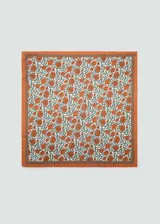 Pañuelo cuadrado con estampado floral en tonos naranja y verde sobre fondo blanco, con borde naranja.