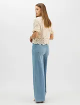 Jegging de tiro alto con silueta estilo palazzo y pierna amplia. Confeccionado en tejido denim con pretina ancha elástica, sin cierre frontal. Presenta diseño frontal liso sin bolsillos y dos bolsillos traseros tipo parche.