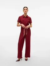 Mono largo color bordó con cuello camisero, cierre frontal de botones, mangas cortas y bolsillos cargo en el pecho. Incluye un cinturón estampado en tonos rojos y beige, y está confeccionado en tejido satinado.