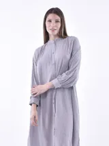 Vestido midi tipo camisero con estampado de rayas verticales en tonos verde y blanco, cuello mao, manga larga y bolsillos laterales.