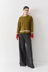 Buzo de lana con cuello redondo, mangas largas con diseño de ochos y puños con abertura para el pulgar. Presenta un diseño tricolor en bloques con franjas en tonos bordó, mostaza y beige.