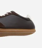 Championes estilo chutera vintage de la marca Satinato, confeccionados en poliuretano con diseño de recortes en gamuza sintética. Presentan punta redonda, cordones al tono y suela de goma dentada en color caramelo, con detalle de talón en contraste.