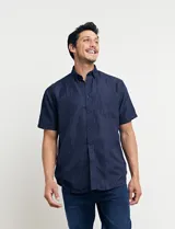 Camisa azul oscuro con pequeños lunares blancos, de manga corta y corte clásico.