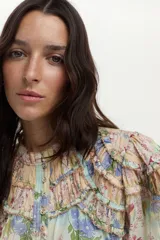 Blusa de algodón y seda con diseño estampado floreado, cuello mao, mangas anchas y detalles de mini volados y bordados en el pecho.