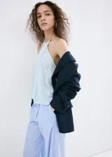Pantalón de corte recto y tiro bajo, de diseño amplio y fluido, con patrón de rayas verticales finas.