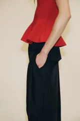 Top negro de escote redondo con tirantes muy finos y bajo acabado en peplum.