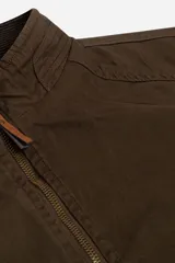 Campera color marrón confeccionada en gabardina suave, resistente y liviana. Diseño clásico con cuello medio y bolsillos laterales con cierre.