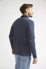 Polo de manga larga para hombre, con diseño a rayas horizontales blancas sobre fondo azul marino. Presenta cuello clásico, cierre frontal con botones y logo bordado en el pecho.