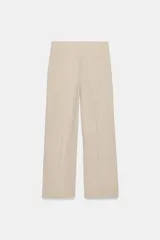 Pantalón de tiro medio confeccionado en lino color beige, de pernera recta con nervios marcados en el delantero. Posee bolsillos frontales, falsos bolsillos de vivo en la espalda y cierre frontal con cremallera, botón interior y gancho.