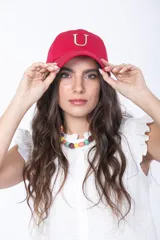 Gorra roja con visera curva y letra "U" bordada en el frente con contorno blanco y relleno amarillo.