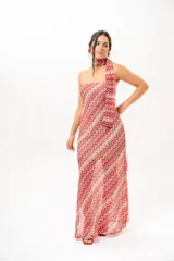 Vestido largo de crochet con escote strapless y lazo integrado para el cuello, con diseño de patrón en zigzag en tonos rojos, blancos y beige, y aberturas laterales en la falda.