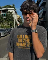 Remera oversize color beige con efecto acid wash y estampa frontal en marrón con la frase "Killing In The Name Of".