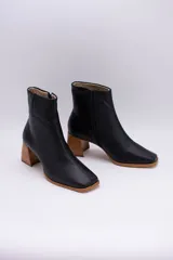 Botas plateadas de cuero con caña media, cierre lateral con cremallera, punta cuadrada y tacón geométrico de madera.