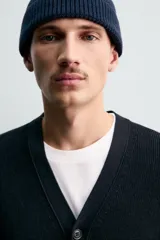 Cárdigan de hombre color negro, de corte regular fit, tejido en estructura compacta, con cuello pico, manga larga y cierre frontal de botonadura.