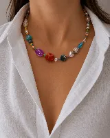Collar corto de cuentas multicolor, con diseño asimétrico que combina esferas de distintos tamaños, texturas y materiales, incluyendo detalles en tonos turquesa, rojo, violeta y azul.