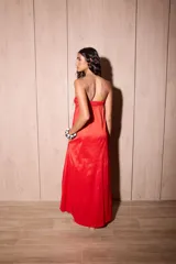 Vestido largo azul con escote strapless, corte suelto y fluido, confeccionado en tafeta con efecto tornasolado, y bolsillos ocultos en los laterales.