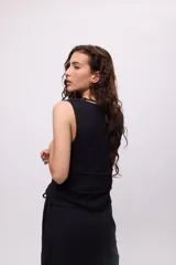 Top sin mangas color blanco, confeccionado en algodón, con escote en V y detalle de tiras cruzadas en el frente.