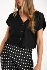 Camisa negra corta de lino y viscosa, con calce oversize, escote en V y cierre frontal con botones.