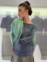 Buzo de doble tejido fino y suave 100% lana merino teñida artesanalmente. Cuenta con una pieza incorporada que permite enroscarla en el cuello a modo de bufanda o chall, dejarla libre hacia el frente o espalda, o enroscarla en el delantero de modo asimétrico. Los puños tienen un ojal para colocar el pulgar y oficiar de semi guantes. Prenda abrigada y confortable ideal para ser usada debajo de un cardigan. Creado y producido en Uruguay.