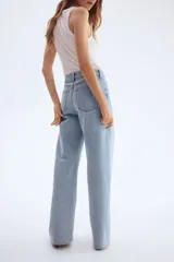 Pantalón de jean celeste de tiro alto, corte ancho y recto, con cinco bolsillos y cierre con botón.