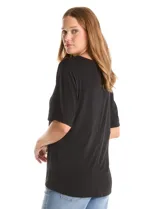Blusa de silueta fluida con escote en V, manga japonesa corta y costura central vertical en el frente. Confeccionada en tejido de punto con acabado mate, presenta un diseño con largo asimétrico, siendo más larga en la espalda.