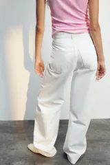 Jeans de mezclilla en color negro gastado, tiro alto, diseño de cinco bolsillos y corte de pierna ancha extra larga. Cuenta con cierre frontal de cremallera y botón metálico.